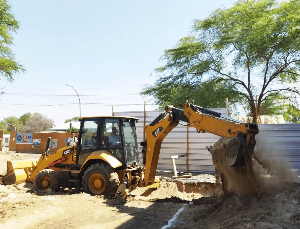 Retroexcavadora realizando trabajos de excavación en la construcción de un colegio en Piura.