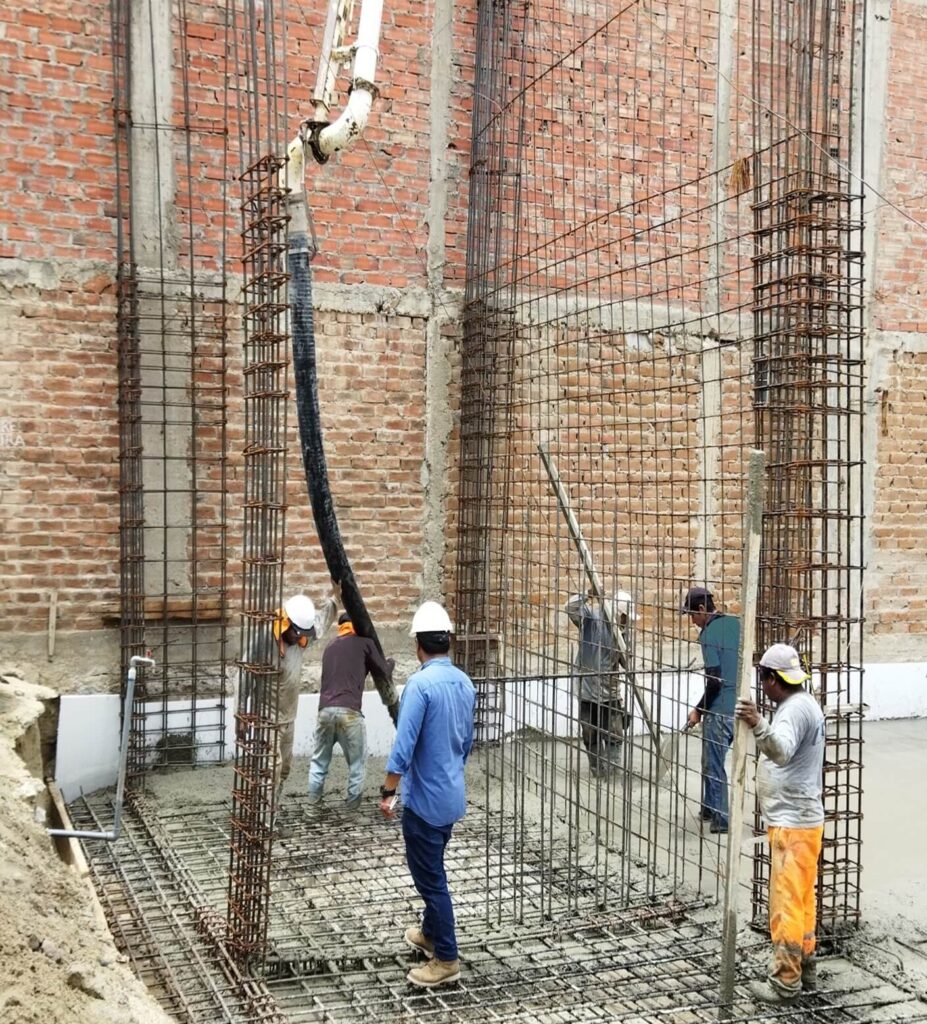 Ingeniero realizando supervision de vaciado de concreto de platea de cimentación.